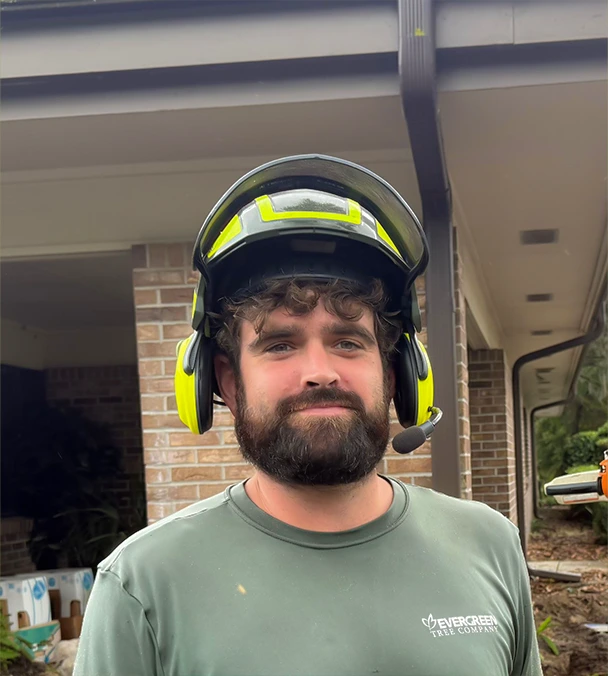 Jake Sherrard, Evergreen Tree Company rigging expert, wearing safety helmet and gear while working from a bucket truck.