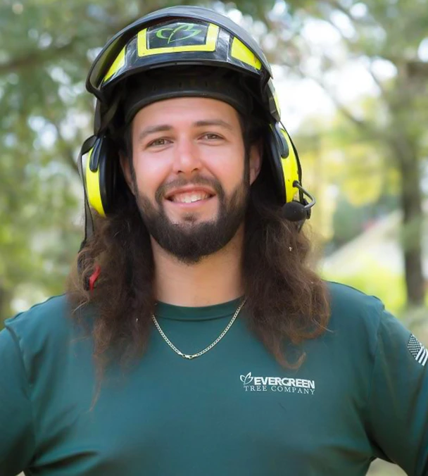 Kyle Willett, Operations Manager and Lead Arborist at Evergreen Tree Company, wearing safety gear and smiling on site.